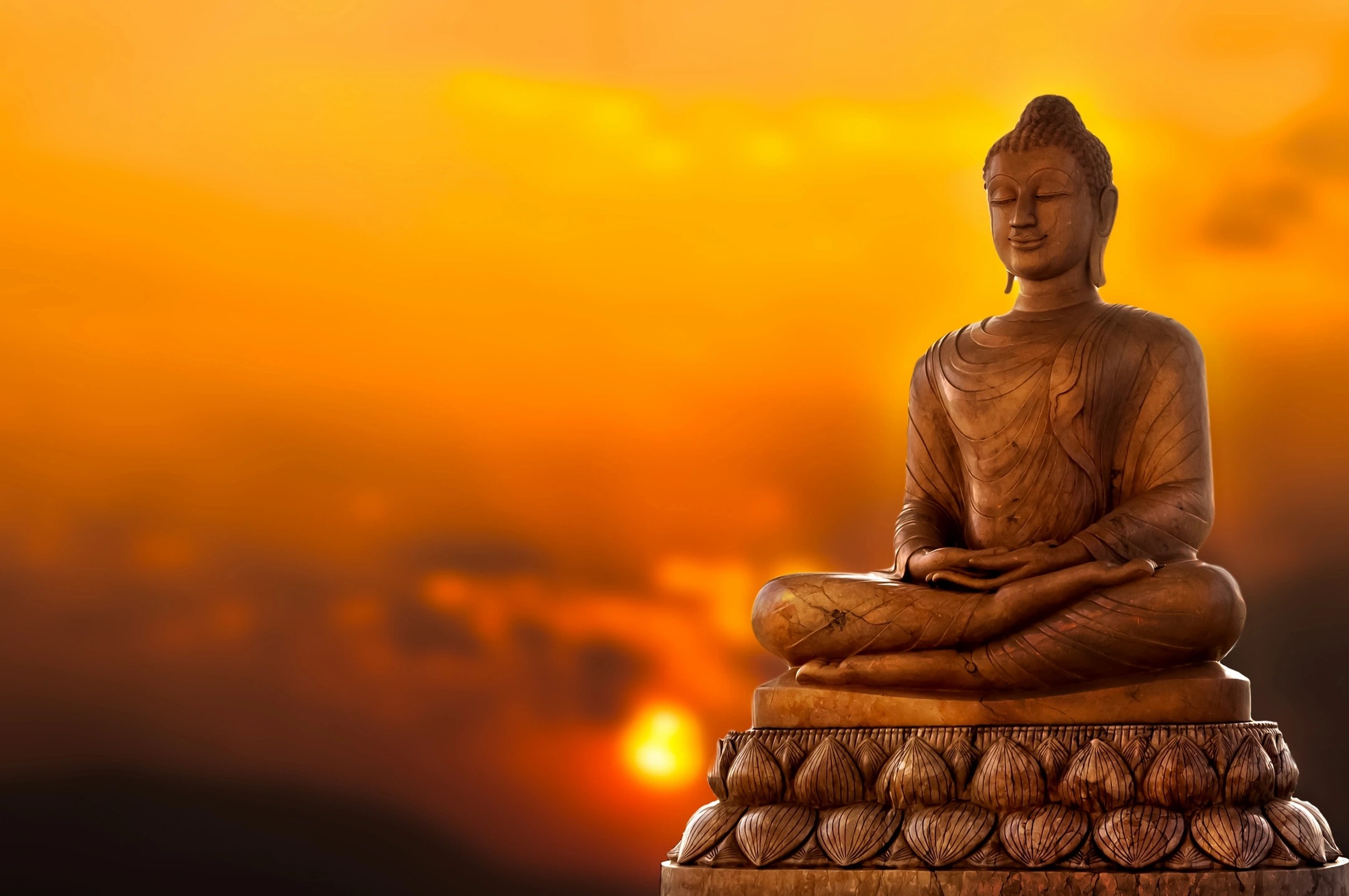 A statue of the Buddha at sunset